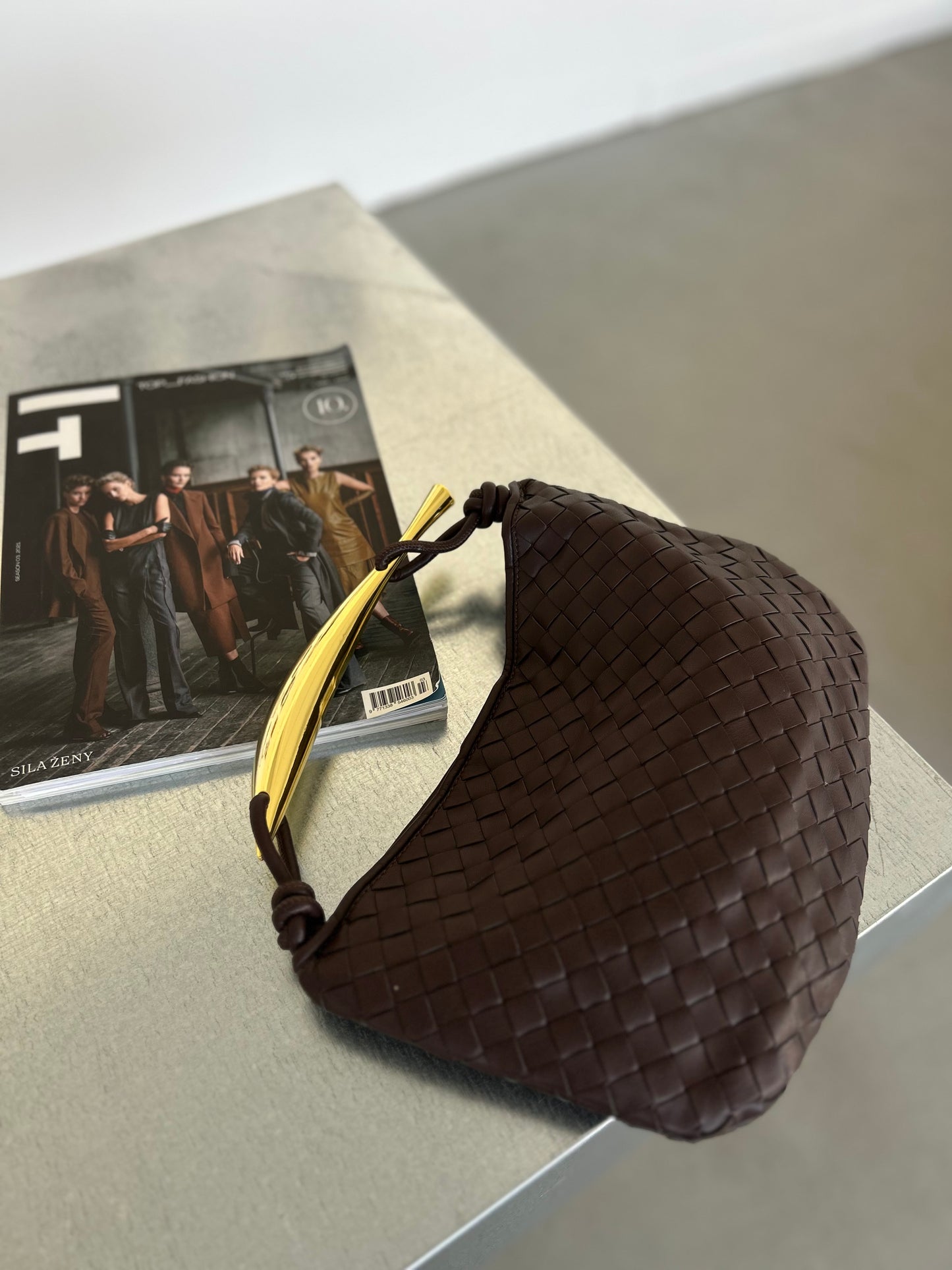 outfit detail fashion inspiration for women who love luxury designer inspired handbags large woven clutch in dark brown colour with gold bar handle, half moon handbag in braided interwoven design which is best selling purse of the year, knoten tasche