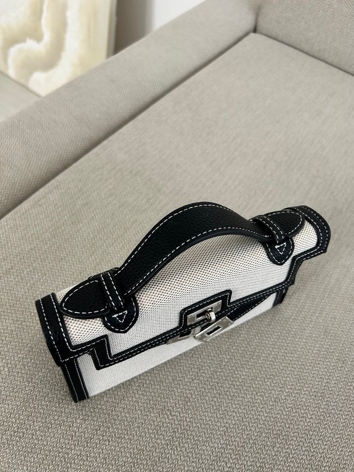 Whether you’re heading to a coffee meeting or jet-setting to your next luxury escape, this bag always delivers main-character energy.
Durable, luxe-quality canvas with leather-look accents
• Bold monochrome colorway for versatile, timeless style
• Eye-catching belt buckle-inspired front detail
• Top handle for elevated elegance + detachable strap ready for boss-on-the-go moments
• Spacious enough for your iPhone, cardholder, lip gloss, and confidence