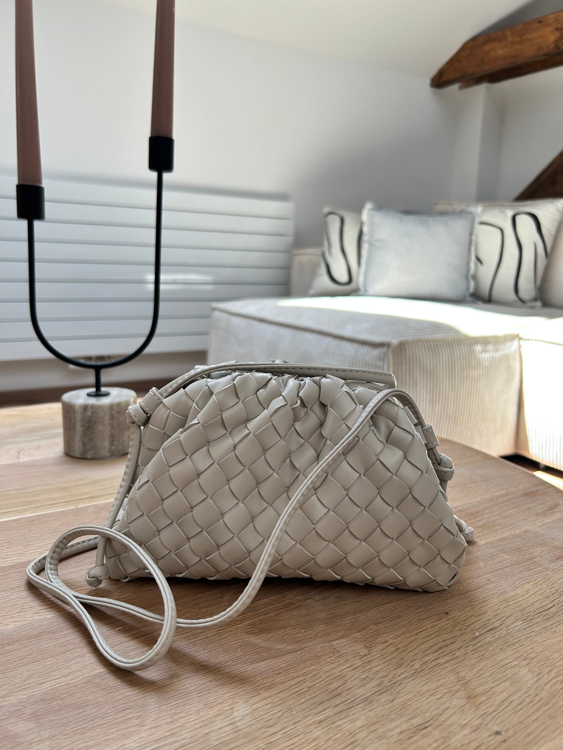 Beige woven crossbody bag crafted from premium vegan leather with an adjustable shoulder strap.