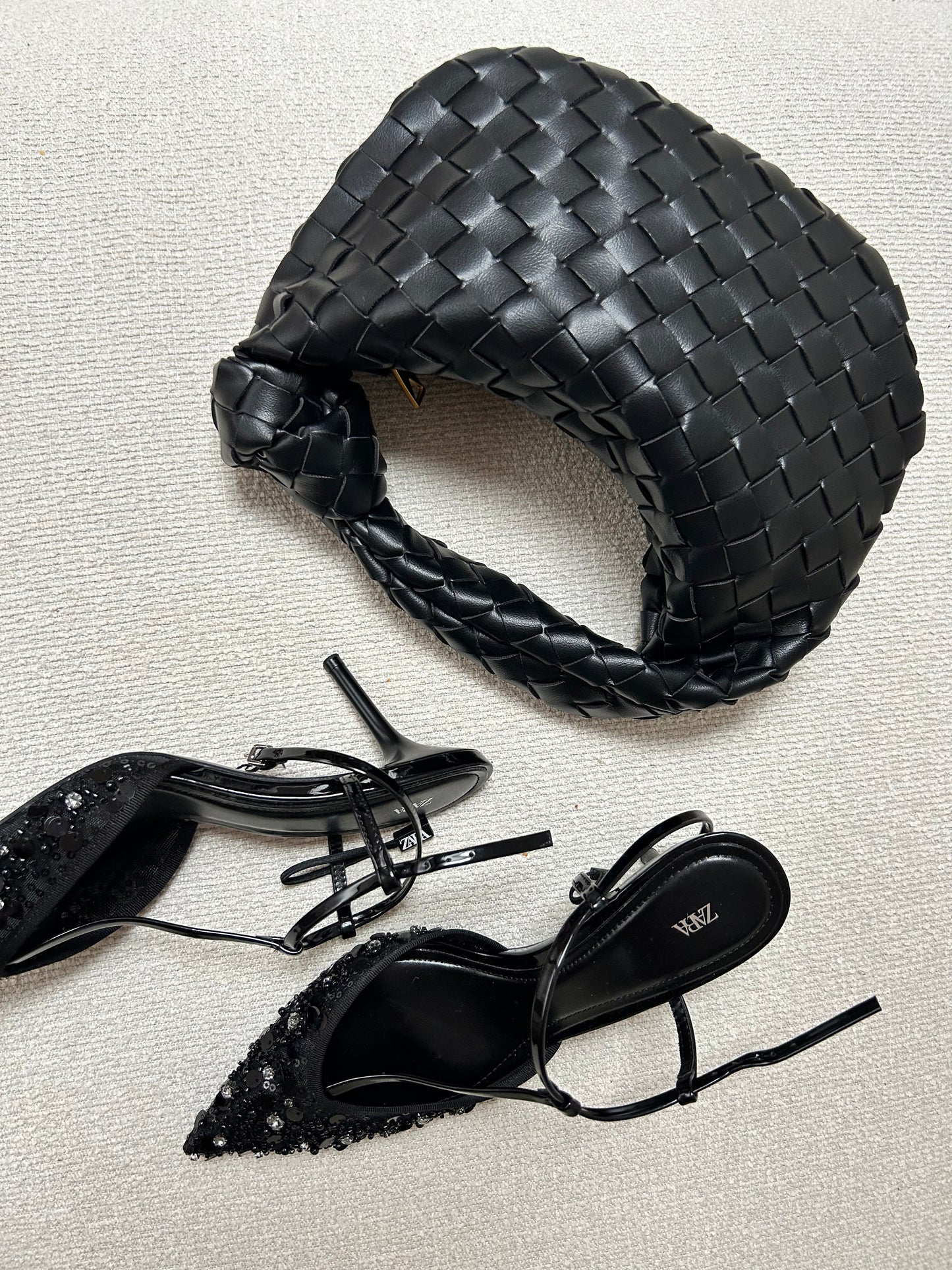 Black woven clutch handbag close-up texture detail