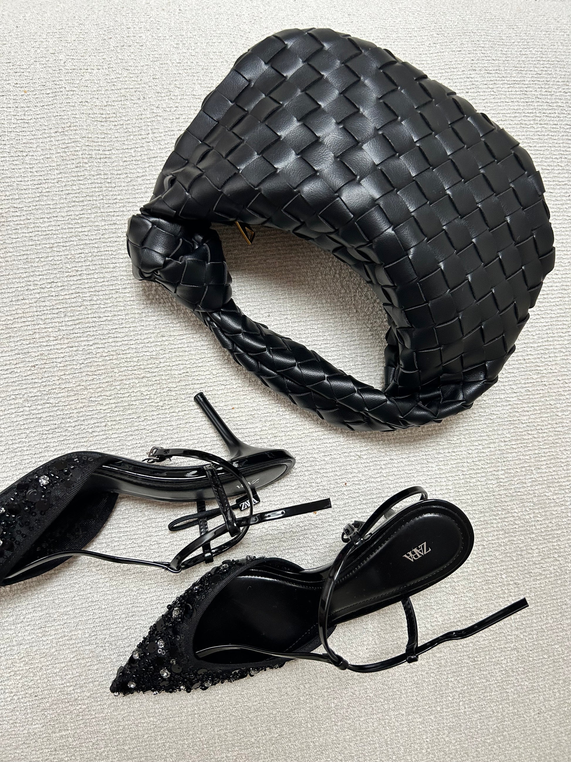 Black woven clutch handbag close-up texture detail