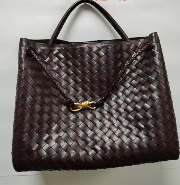 Brown woven handbag with a gold clasp on a white background
