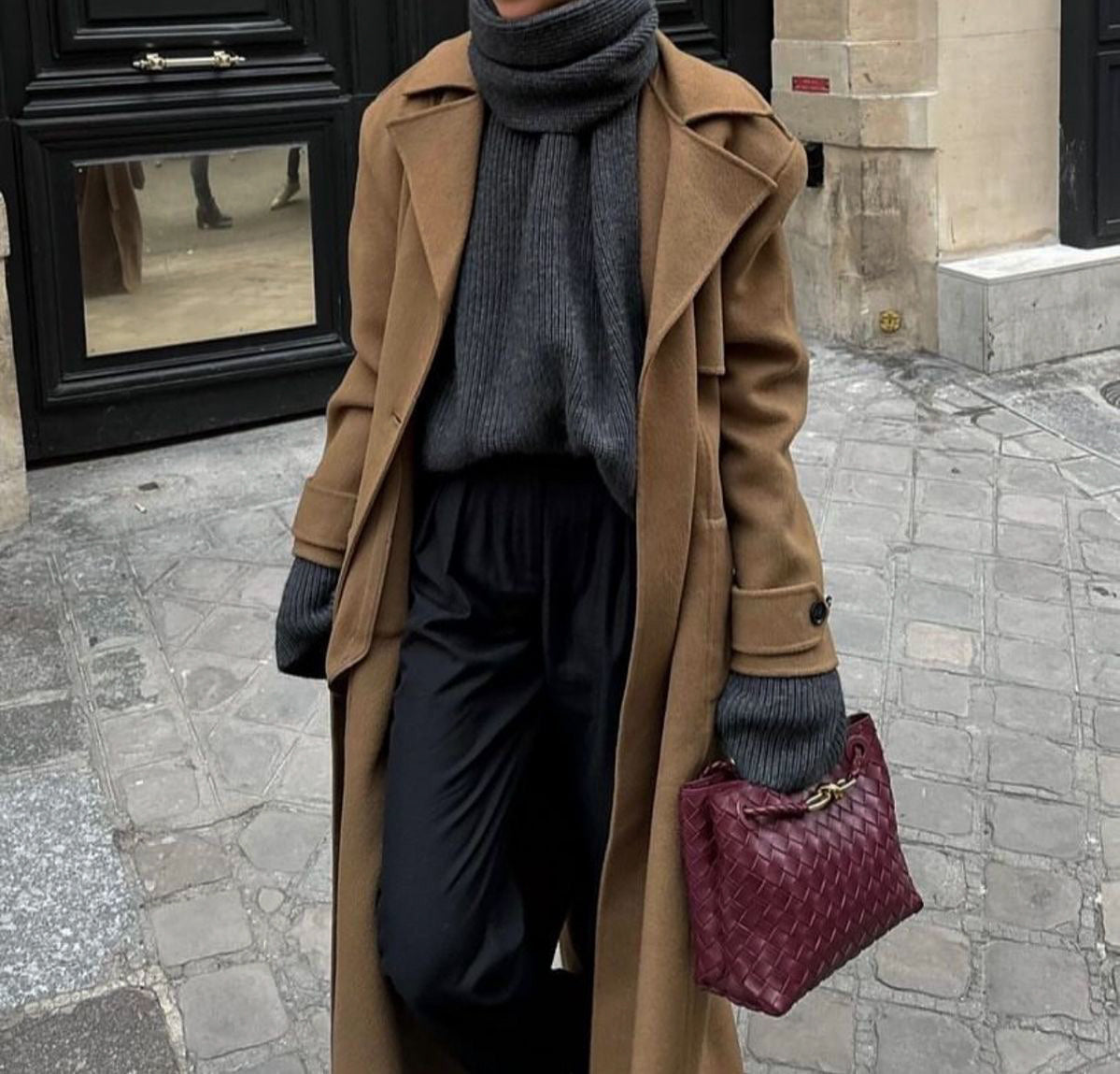 Burgundy woven handbag by PattyB with gold knot detail, styled with a grey coat and knit skirt — luxury vegan leather fashion accessory.