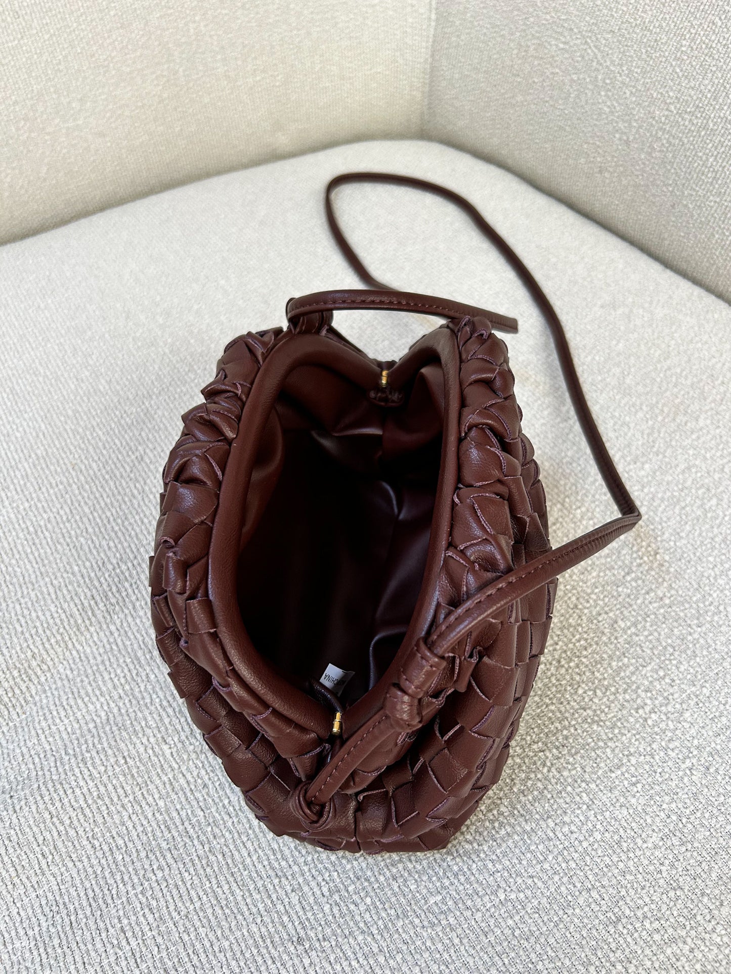 Inside of a brown crossbody handbag in braided deign. With enough room for essentials like a phone, wallet, and makeup, it strikes the perfect balance between functionality and style, making it a go-to for busy women who want to look effortlessly polished.