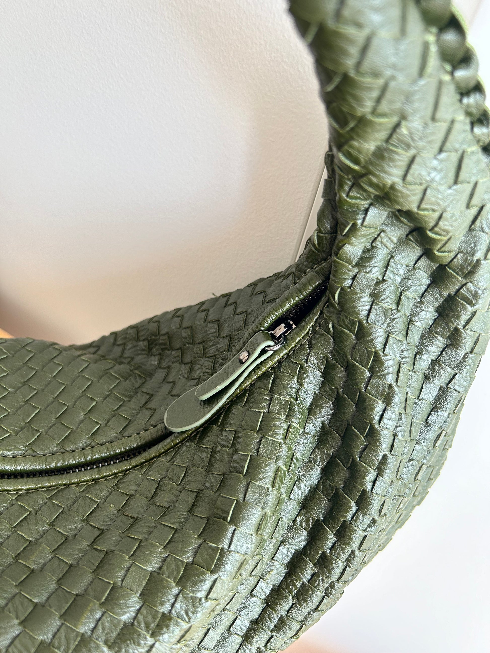 Close-up of textured woven green handbag