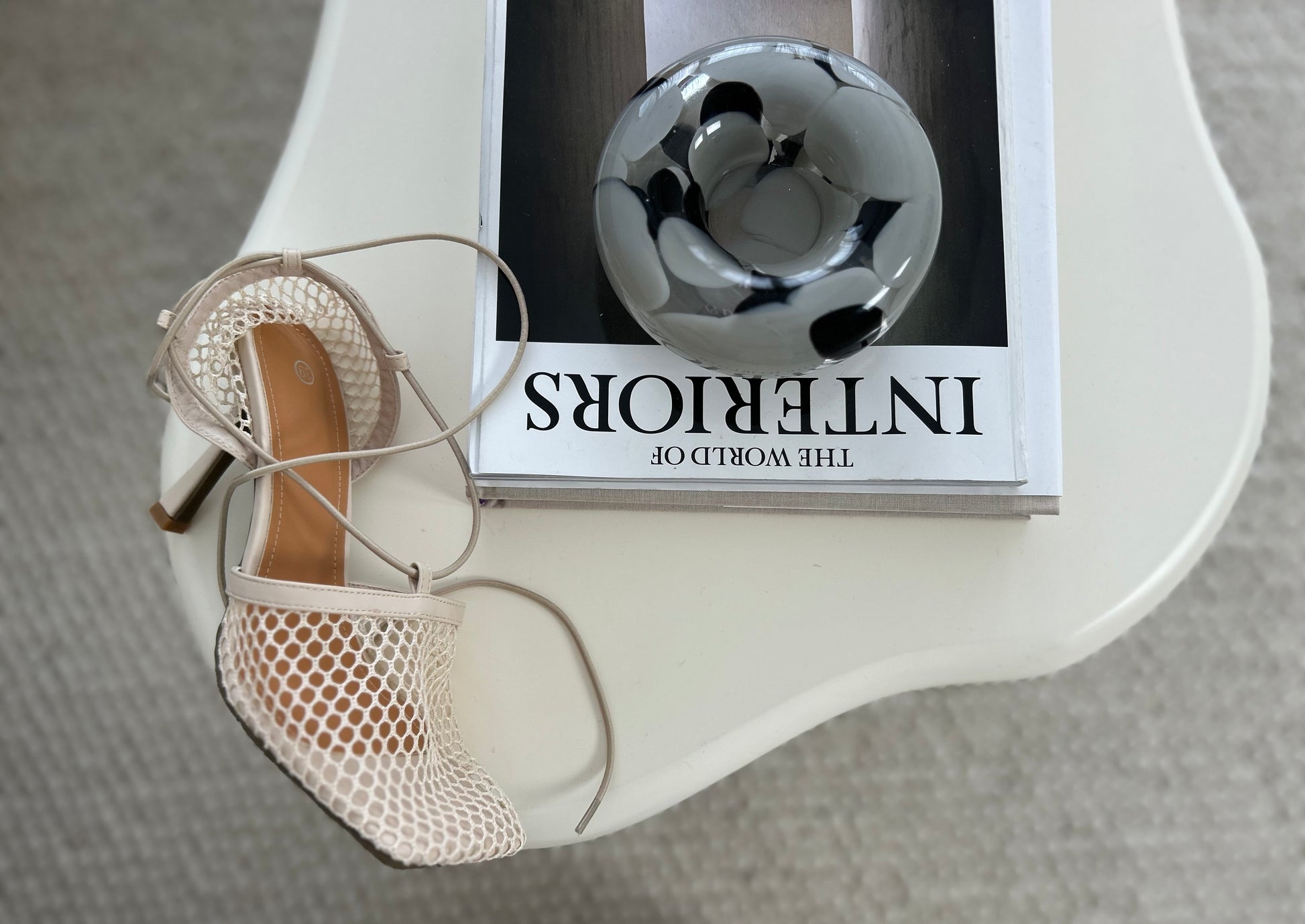 Designer-inspired flat sandals with lace-up straps on indoor lifestyle setting