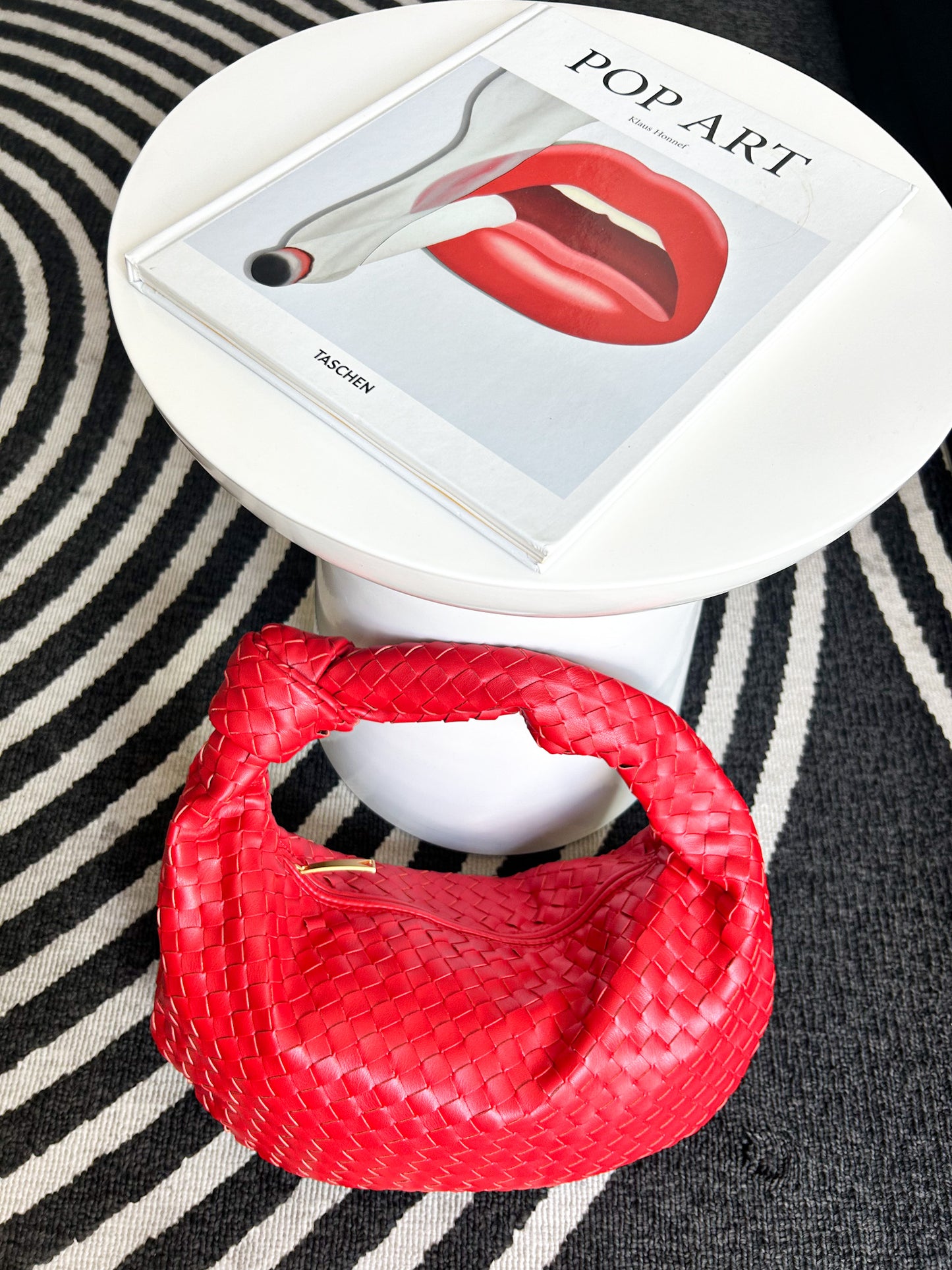 Designer-inspired red shoulder bag featuring soft woven texture and modern hobo silhouette.