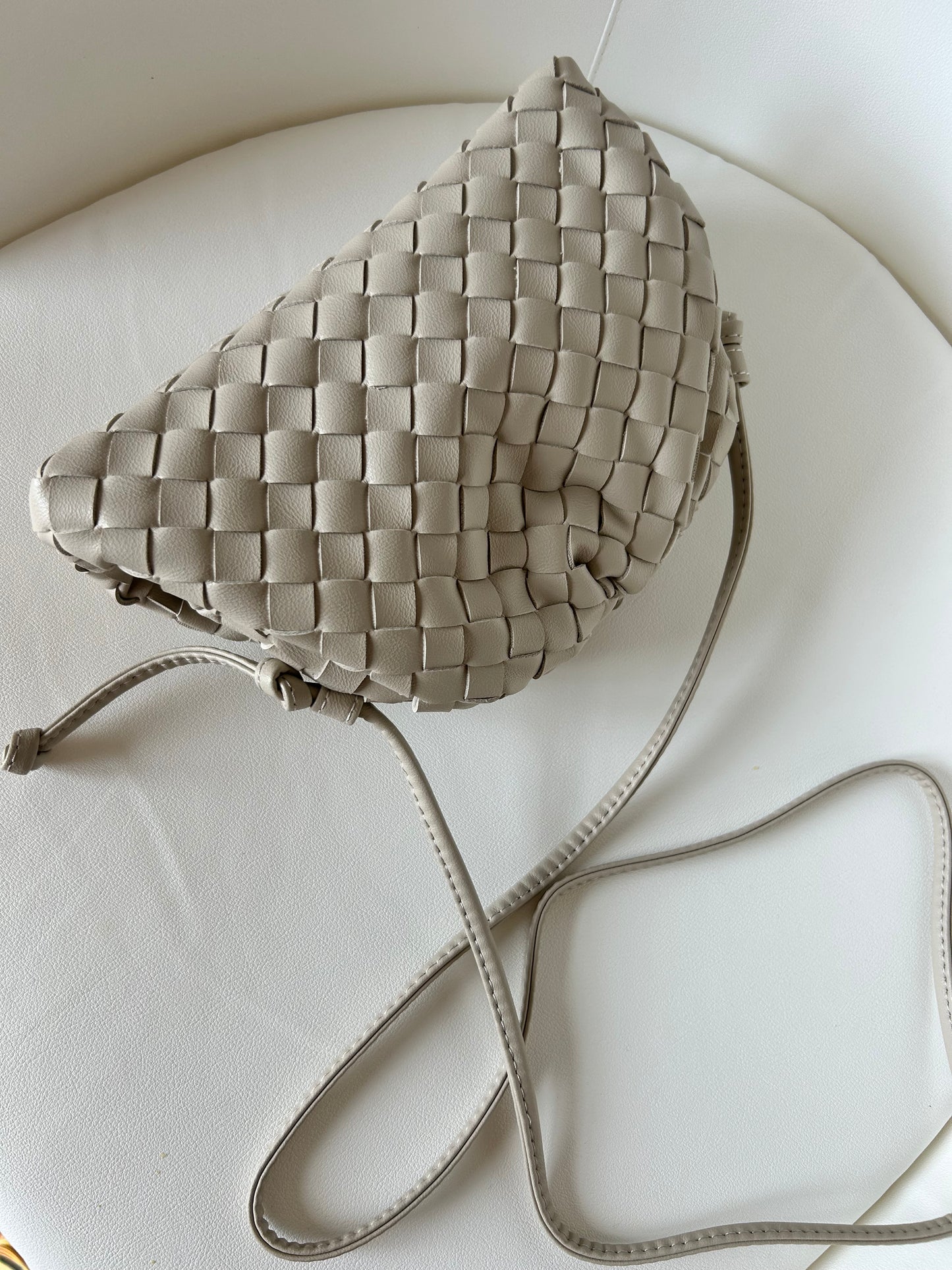 Elegant vegan leather crossbody bag in beige with luxury-inspired woven detailing.