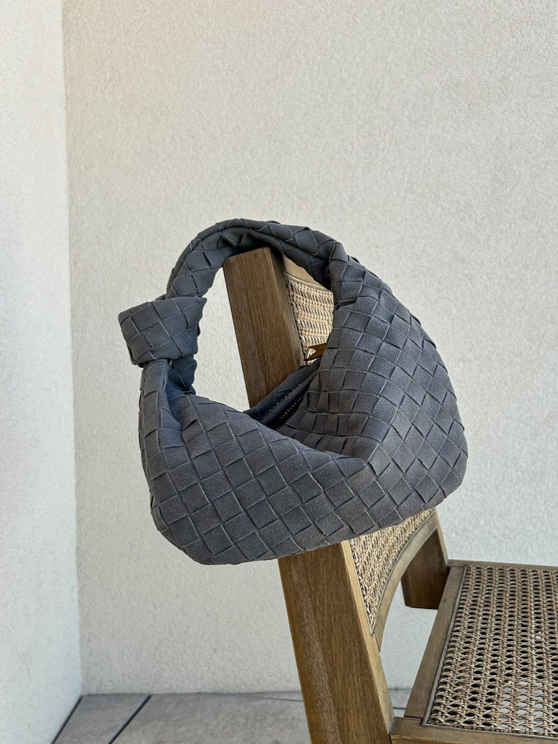 Elevate your everyday look with this chic and stylish woven clutch. This sustainable hobo purse is perfect for the eco-conscious fashionista. Crafted from high-quality vegan leather with a suede knot detail and braided accents.