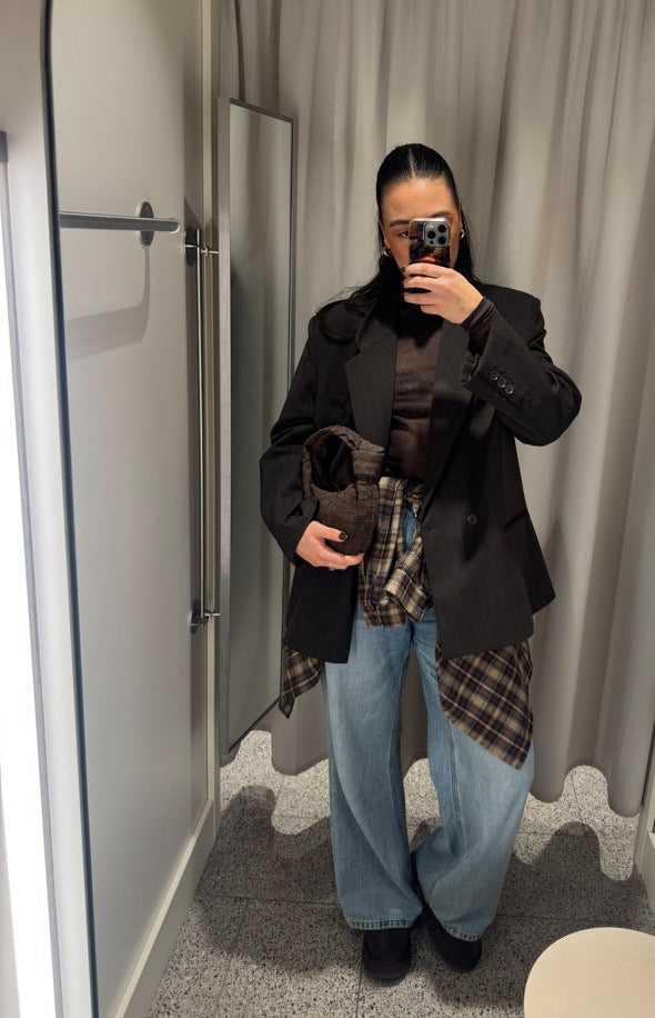 Handheld chocolate brown teddy clutch bag worn with casual outfit