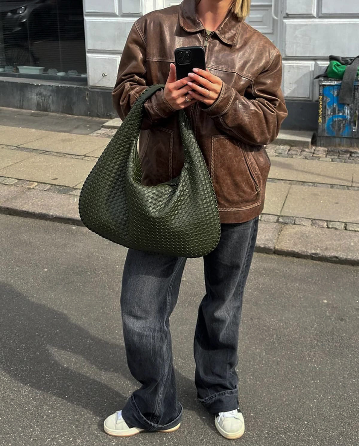Military green woven hobo bag styled casually with denim