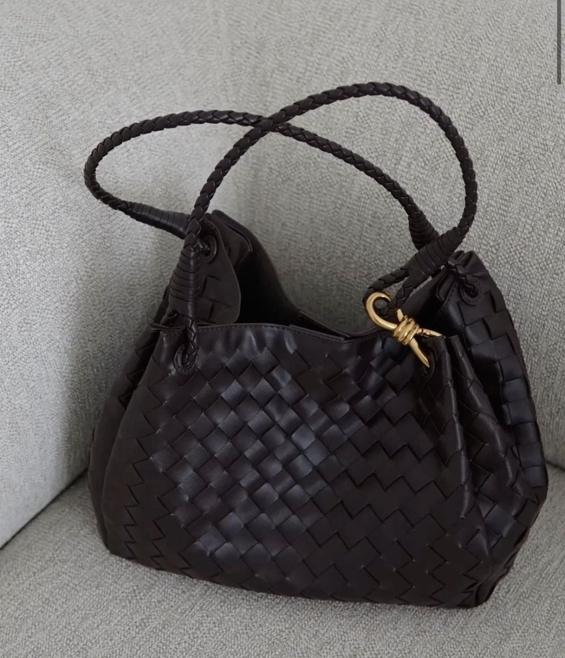Minimalist brown shoulder bag styled on chair