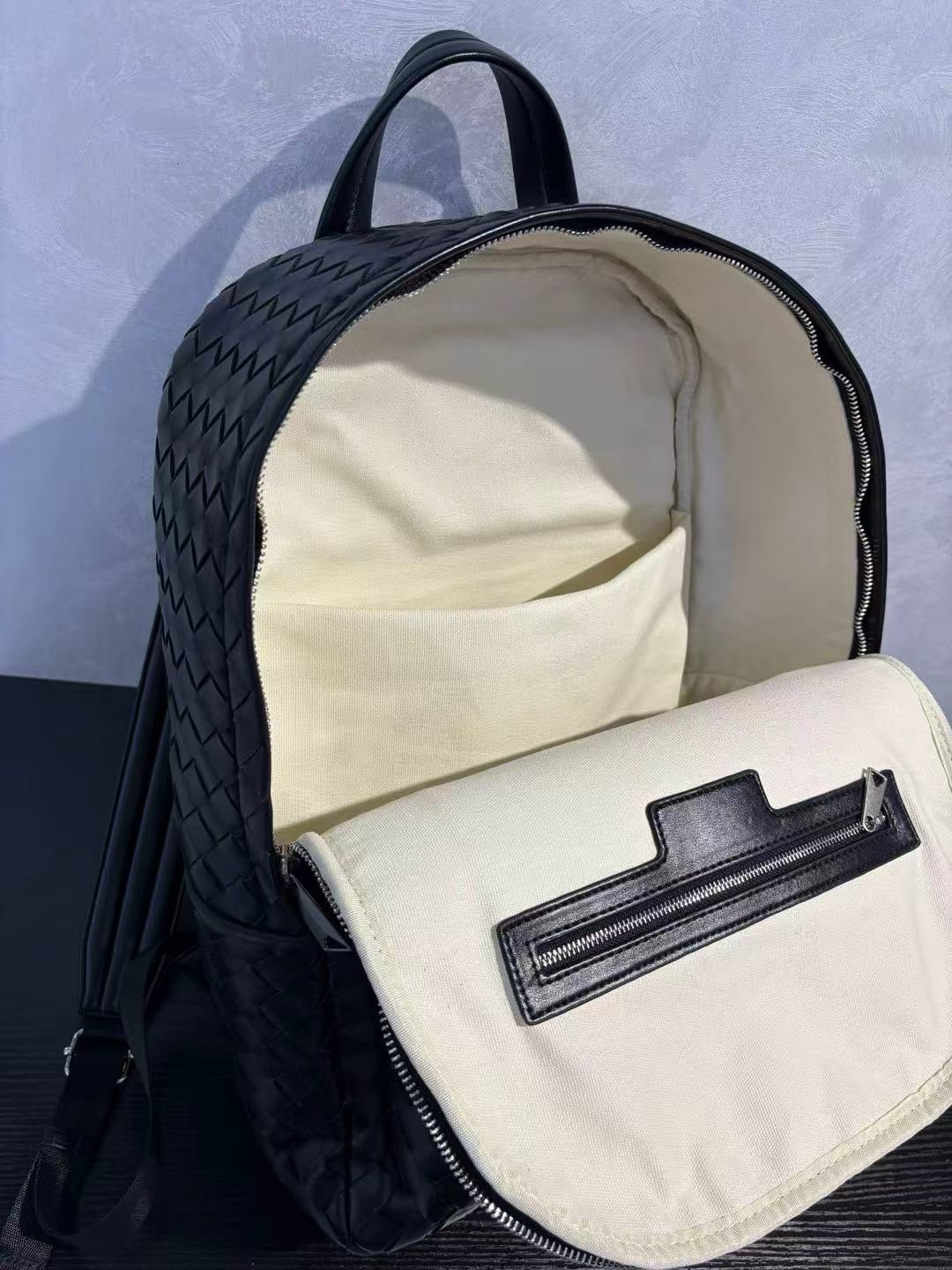 Minimalist unisex woven leather backpack styled outdoors featuring elegant black cowhide leather texture.