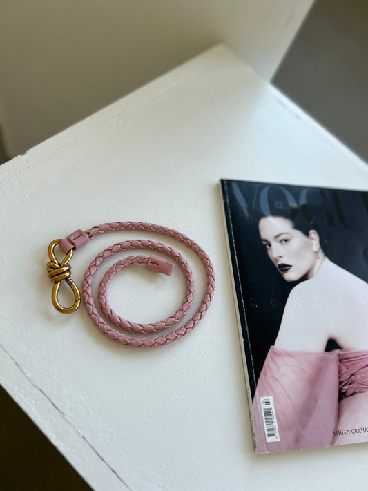 Luxury woven texture pink belt for everyday wear, elegantly placed next to a matching magazine for an aesthetic look. Featuring a stylish braided design, this chic accessory adds a timeless touch to casual and formal outfits, perfect for any wardrobe.