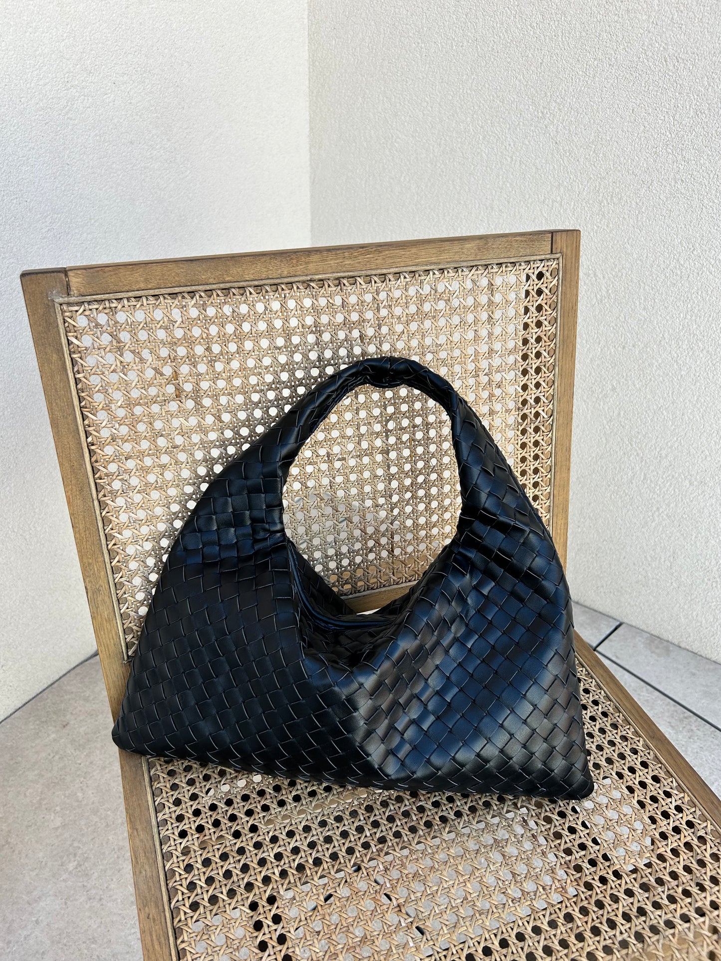Quiet luxury black woven shoulder bag with structured silhouette