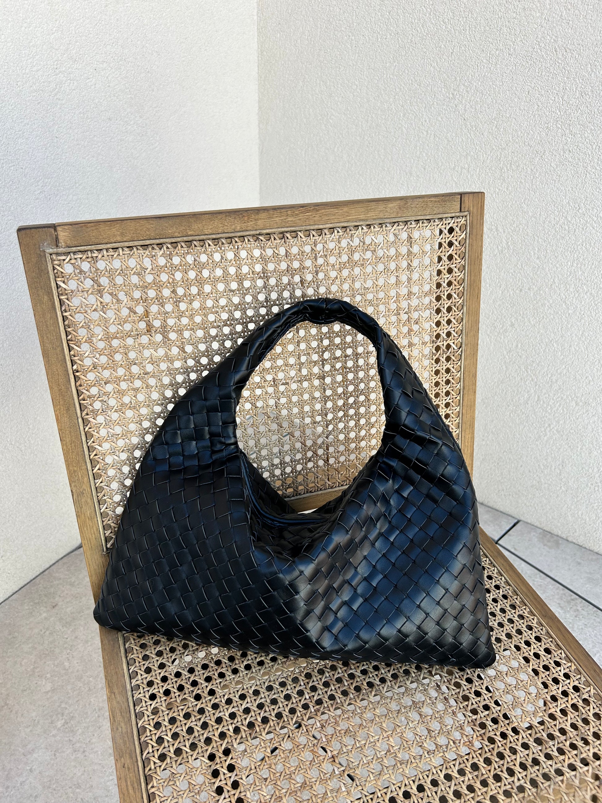 Quiet luxury black woven shoulder bag with structured silhouette
