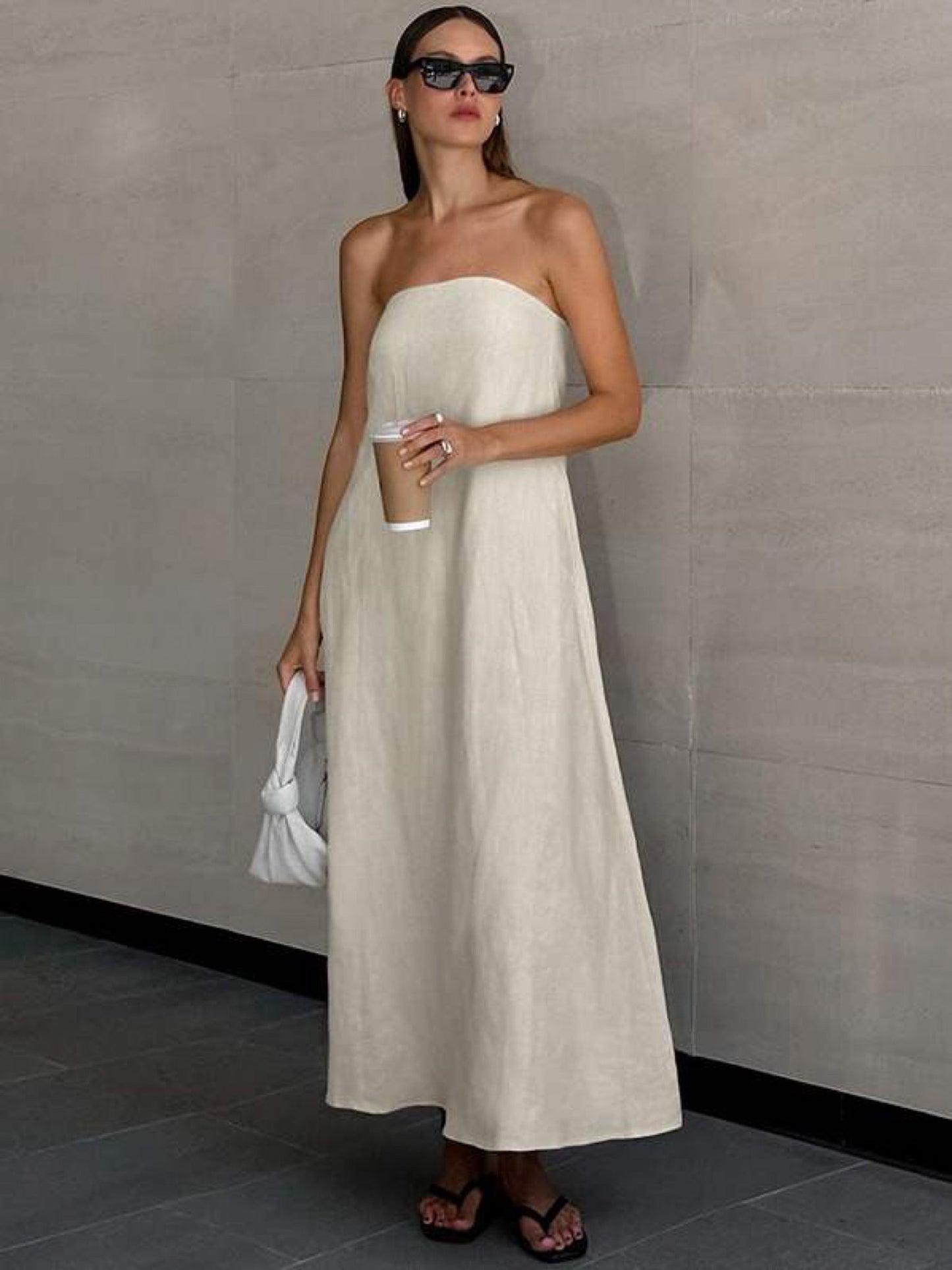 Quiet luxury strapless maxi dress with hidden side pockets and effortless summer styling.