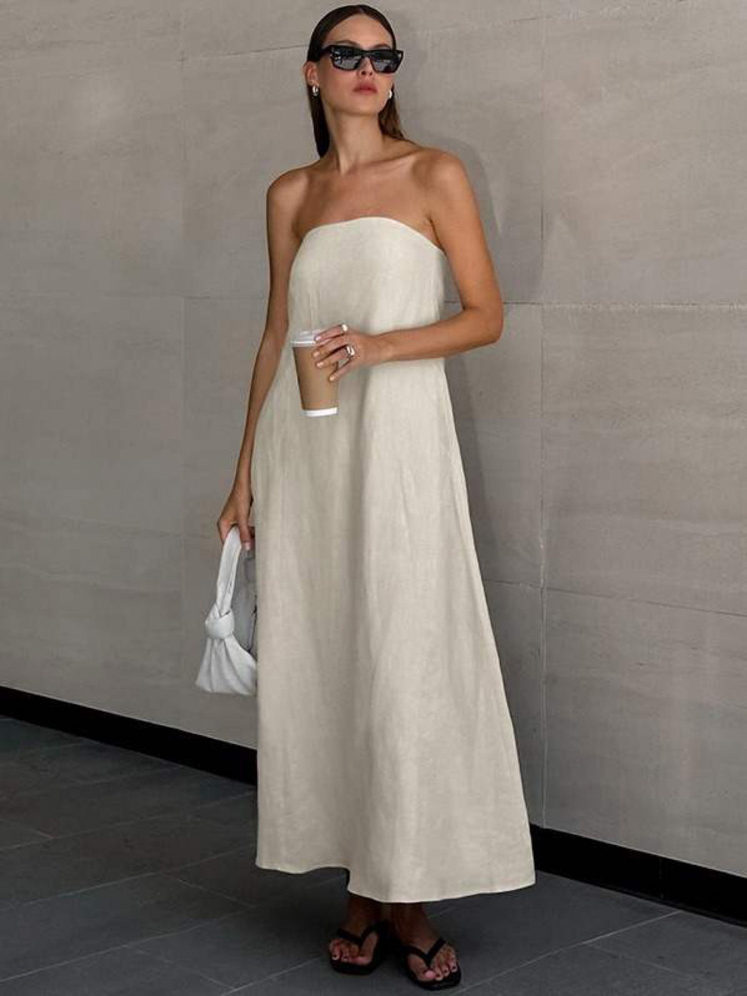Quiet luxury strapless maxi dress with hidden side pockets and effortless summer styling.