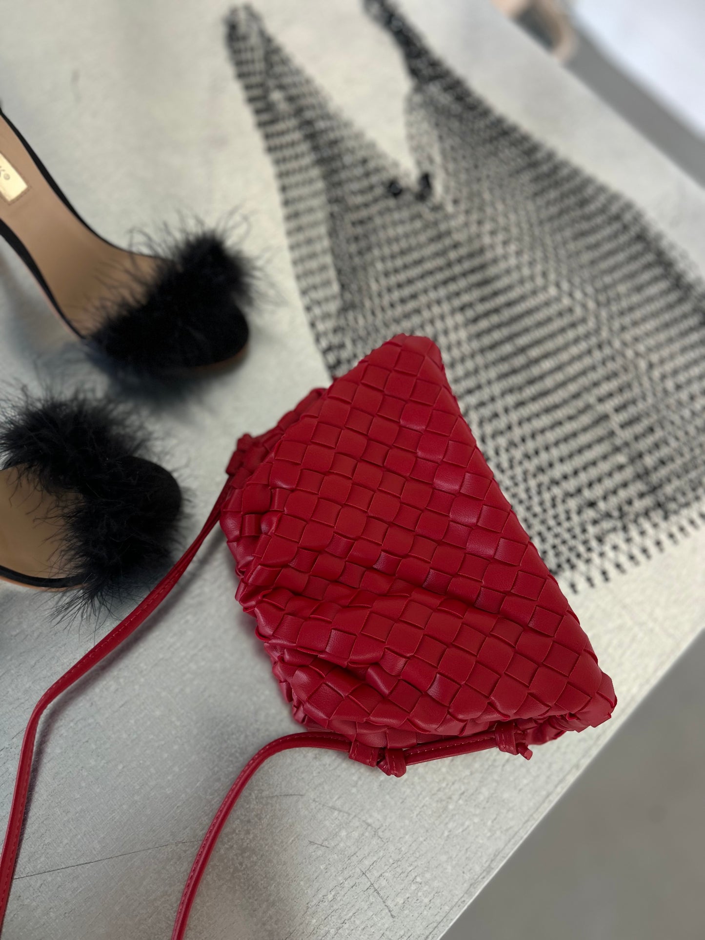 Red woven crossbody bag crafted from premium vegan leather with an adjustable shoulder strap and elegant woven texture.