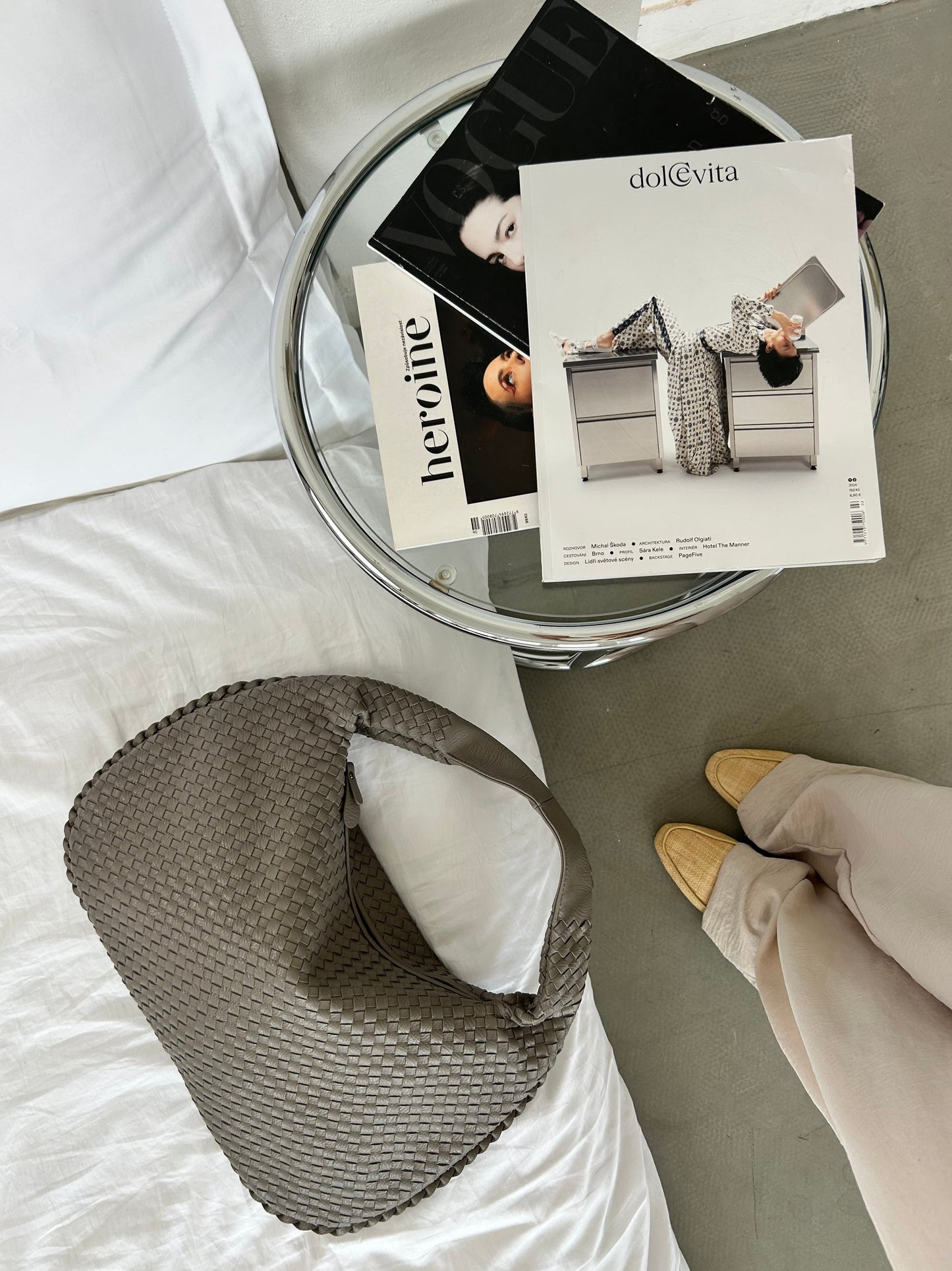 Taupe minimalist shoulder bag on bed with neutral outfit aesthetic