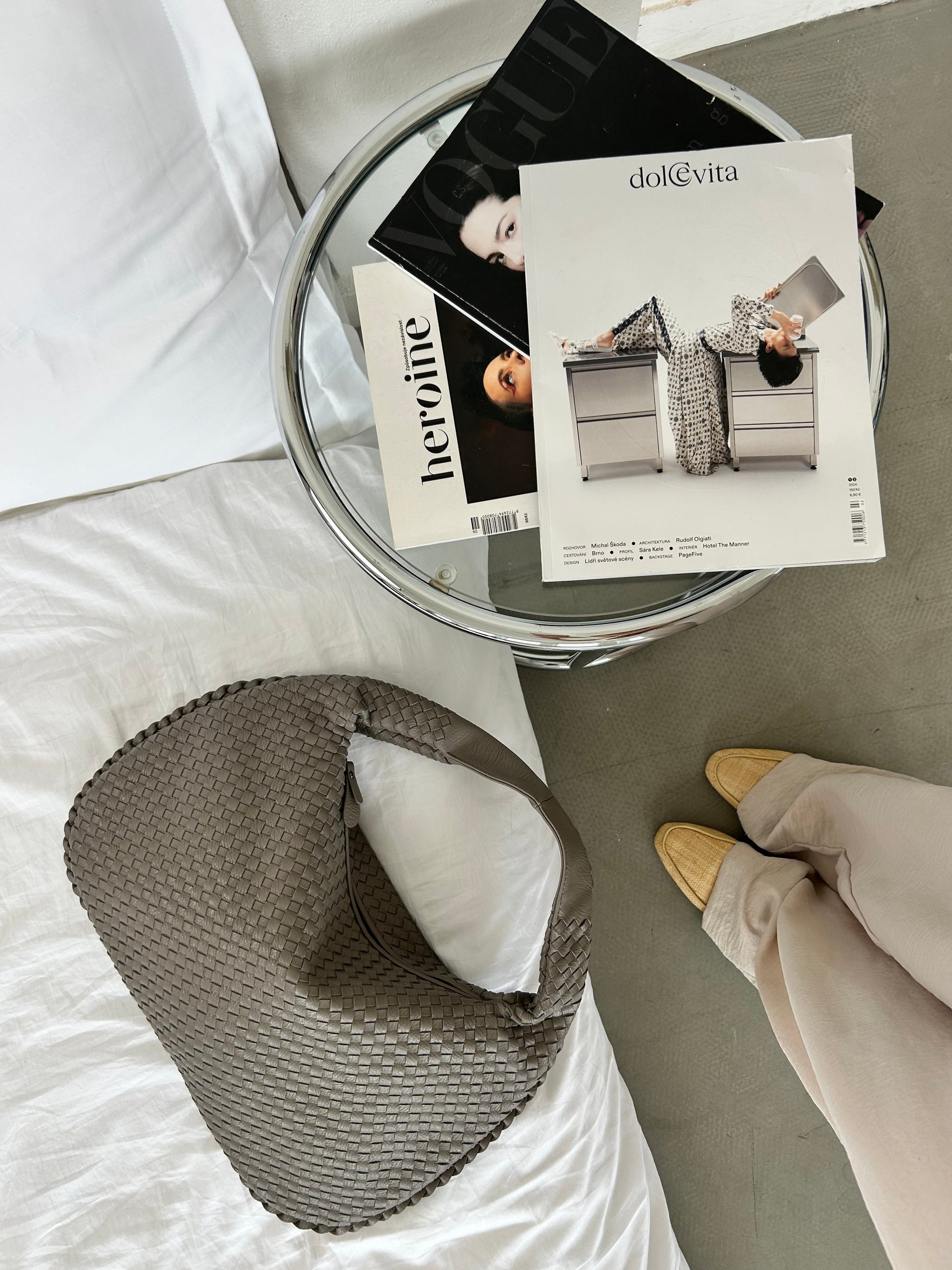 Taupe minimalist shoulder bag on bed with neutral outfit aesthetic
