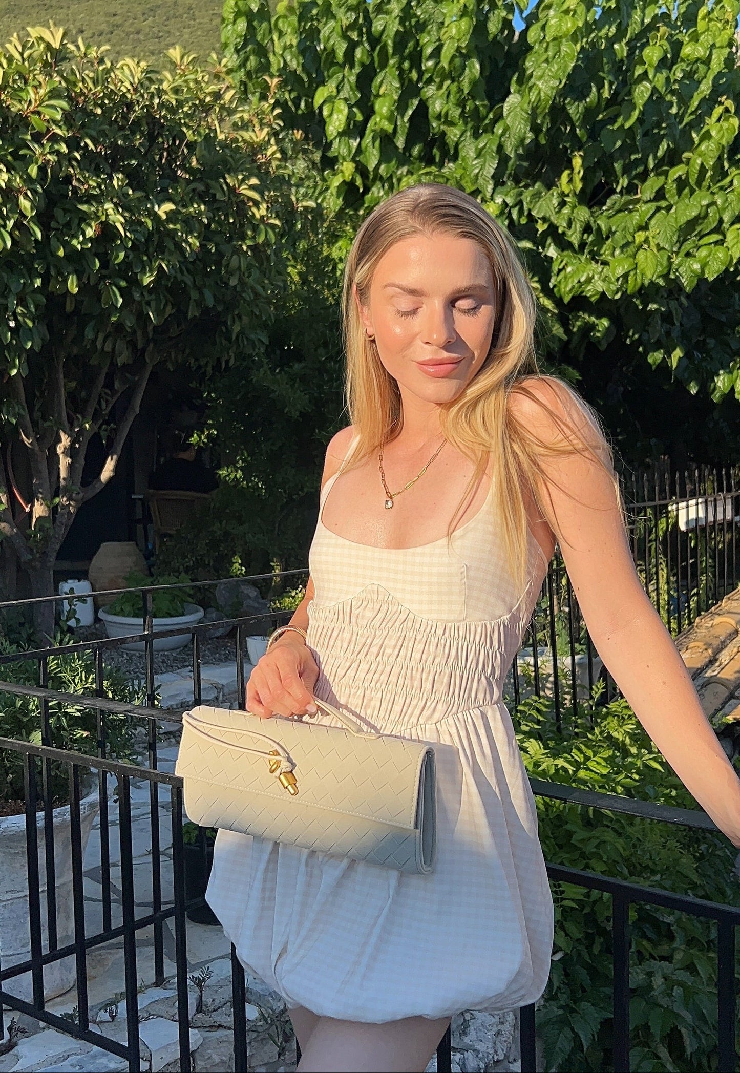 Woman wearing taupe woven vegan suede crossbody bag with adjustable strap.
