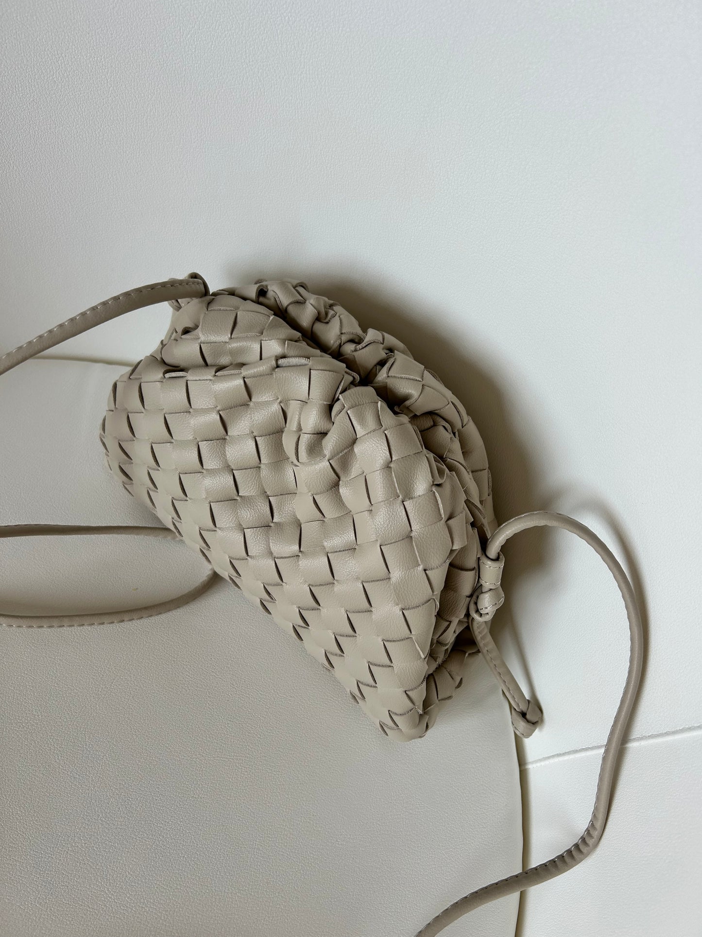 Women's beige woven crossbody purse featuring a lightweight everyday design and secure zip closure.