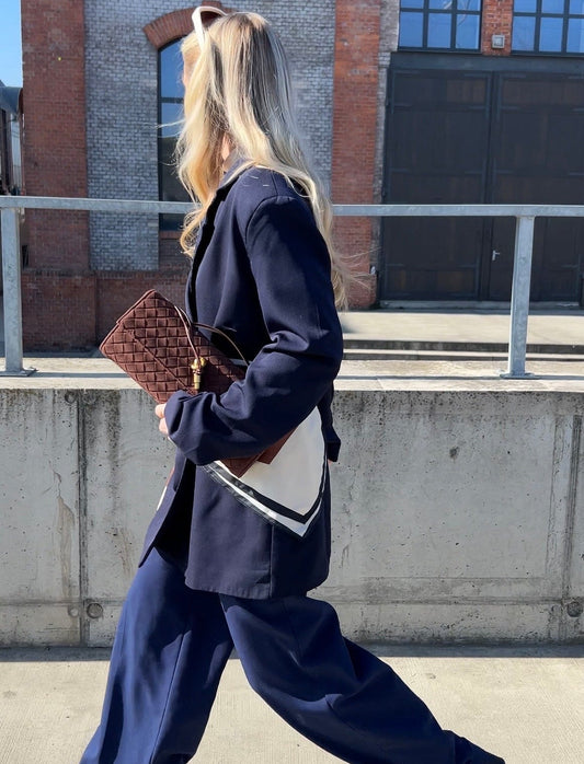 Women’s brown suede clutch styled with navy outfit