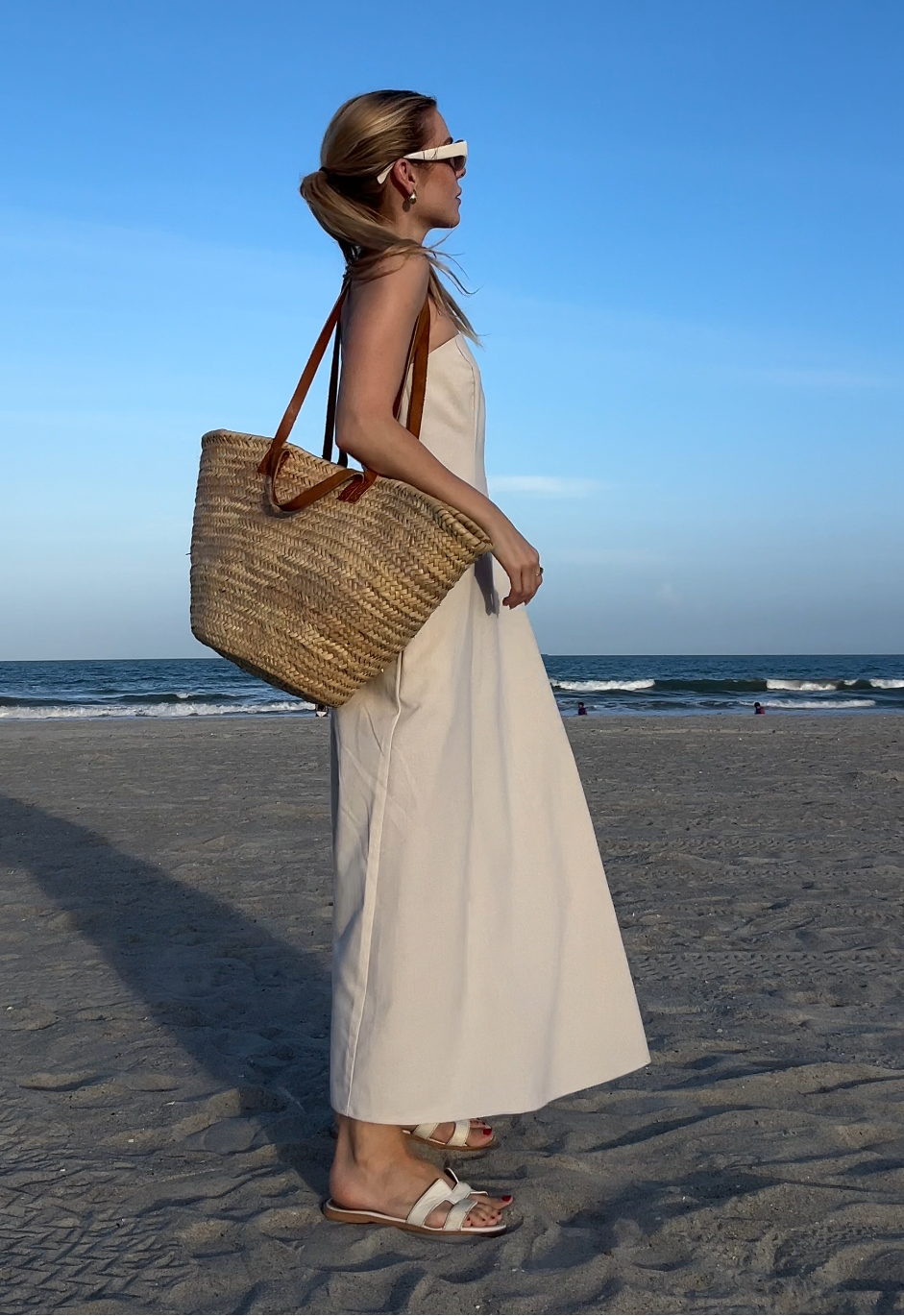 Women's strapless linen maxi dress with hidden pockets styled for an elegant beach vacation.
