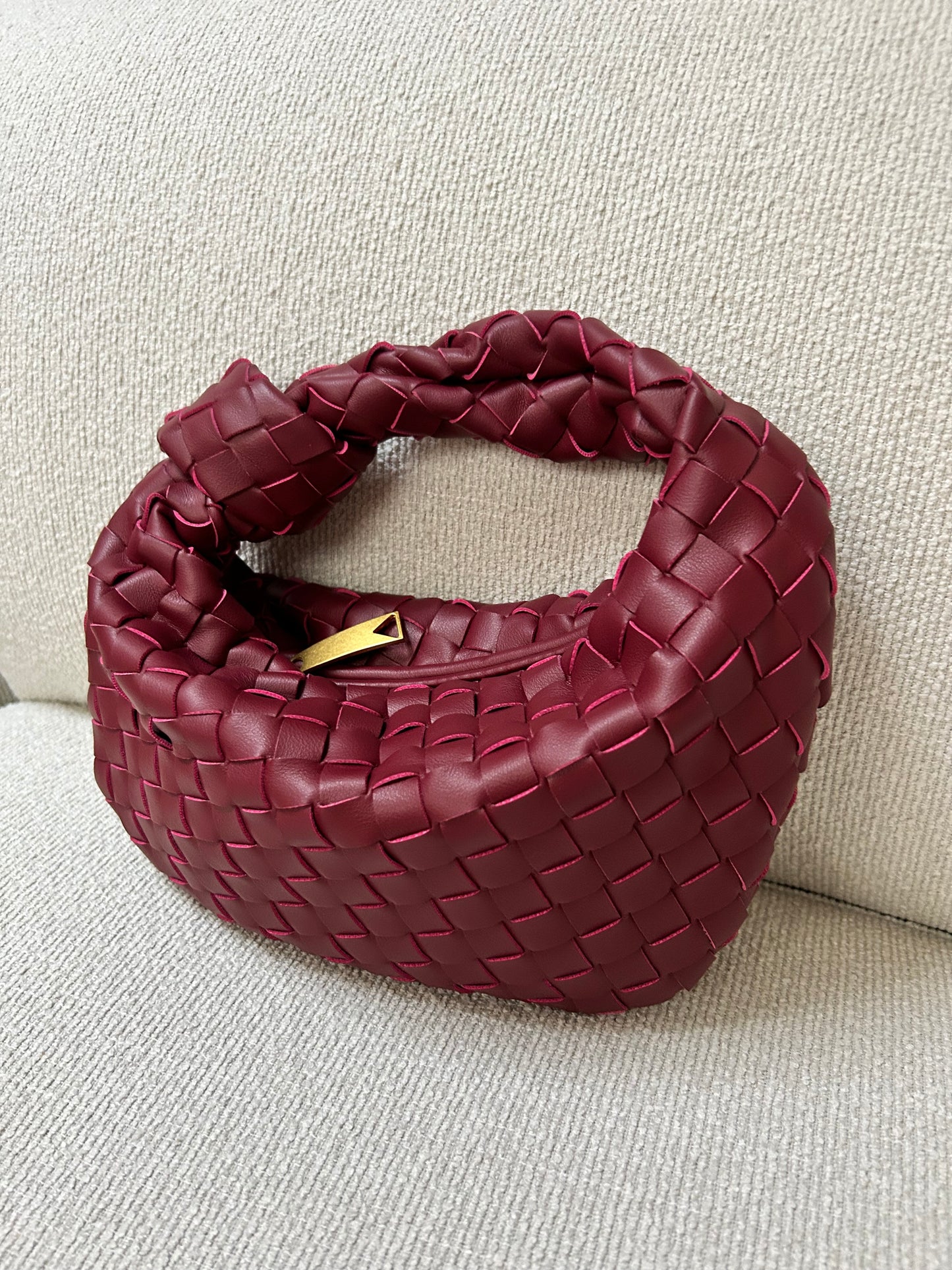 compact woven clutch bag in merlot colour with soft structured silhouette modern design