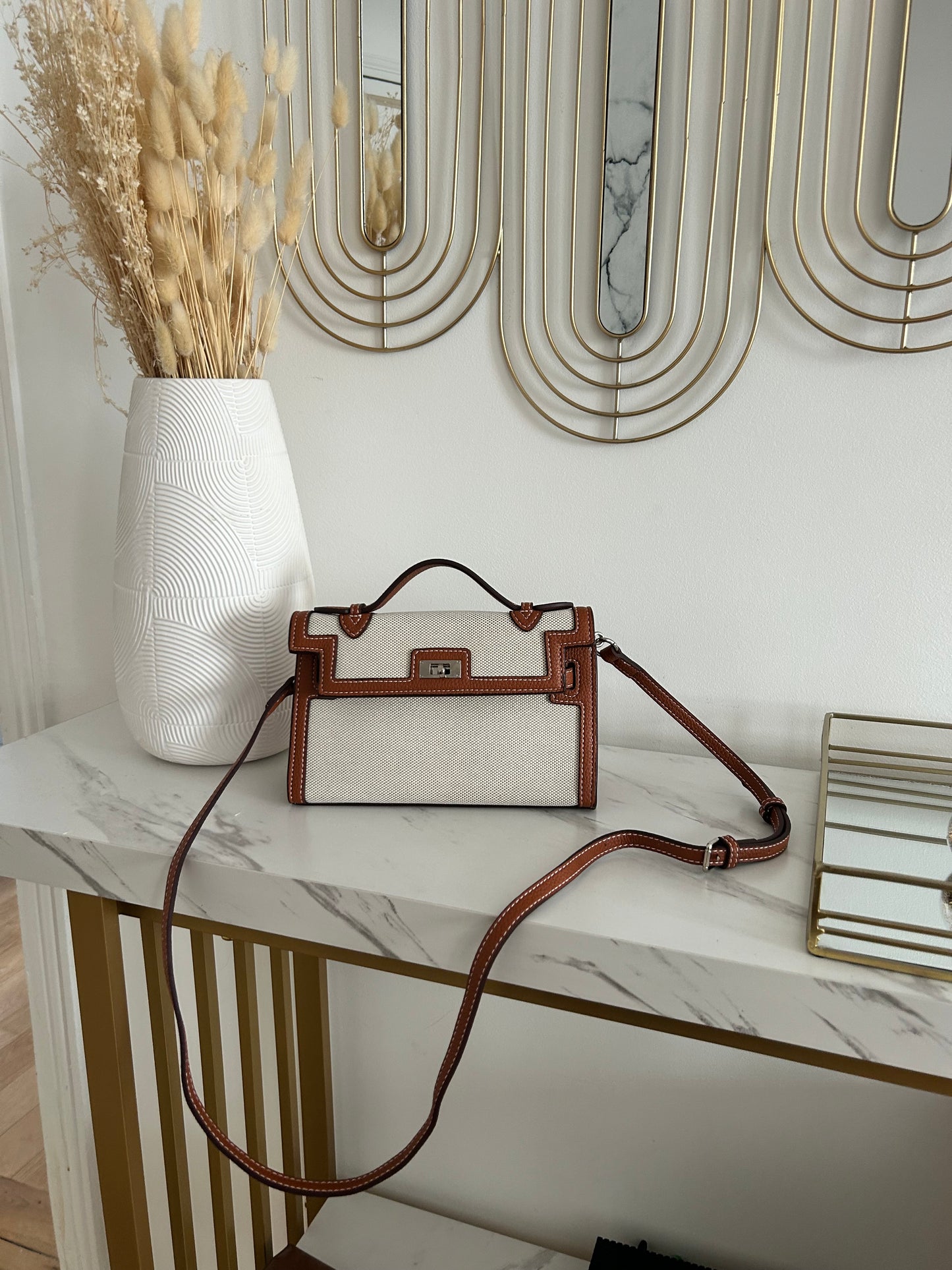Durable, luxe-quality canvas with leather-look accents
Bold monochrome colorway for versatile, timeless style
Eye-catching belt buckle-inspired front detail
Top handle for elevated elegance + detachable strap ready for boss-on-the-go moments