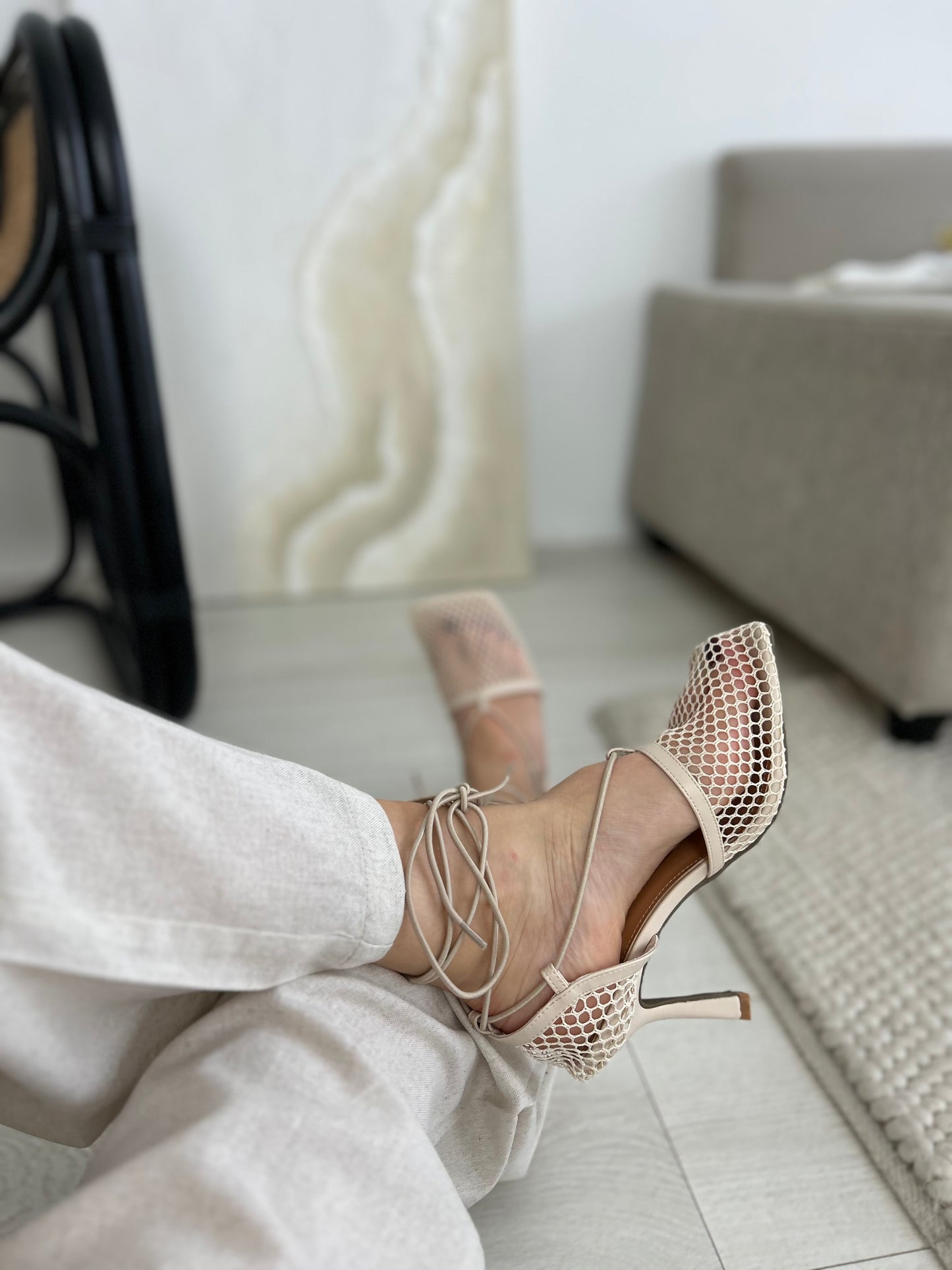 Chic fashion photo showing beige mesh open-toe heels with sleek ankle wrap laces and a 10cm stiletto heel, styled with casual black pants for a classy yet daring streetwear look.

Keywords: beige open-toe heels, lace-up mesh stilettos, designer-inspired footwear, fashion heels 2025
