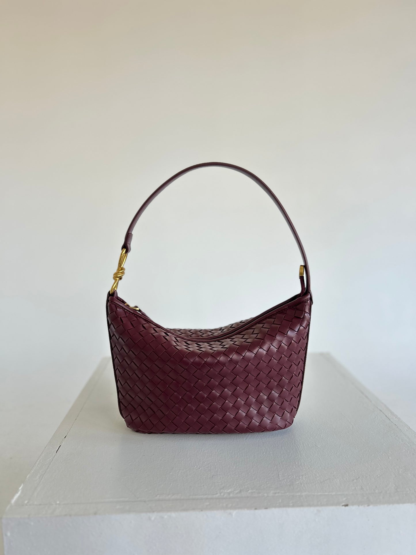 Stylish Woven Shoulder Bag placed casually on a cream sofa with minimalist pillows, Elegant Braided Handbag in burgundy colour is suitable for Everyday Carry, Hobo Woven Bag Practical Bag for Work Braided Handle Handbag, best birthday Gift for Wife