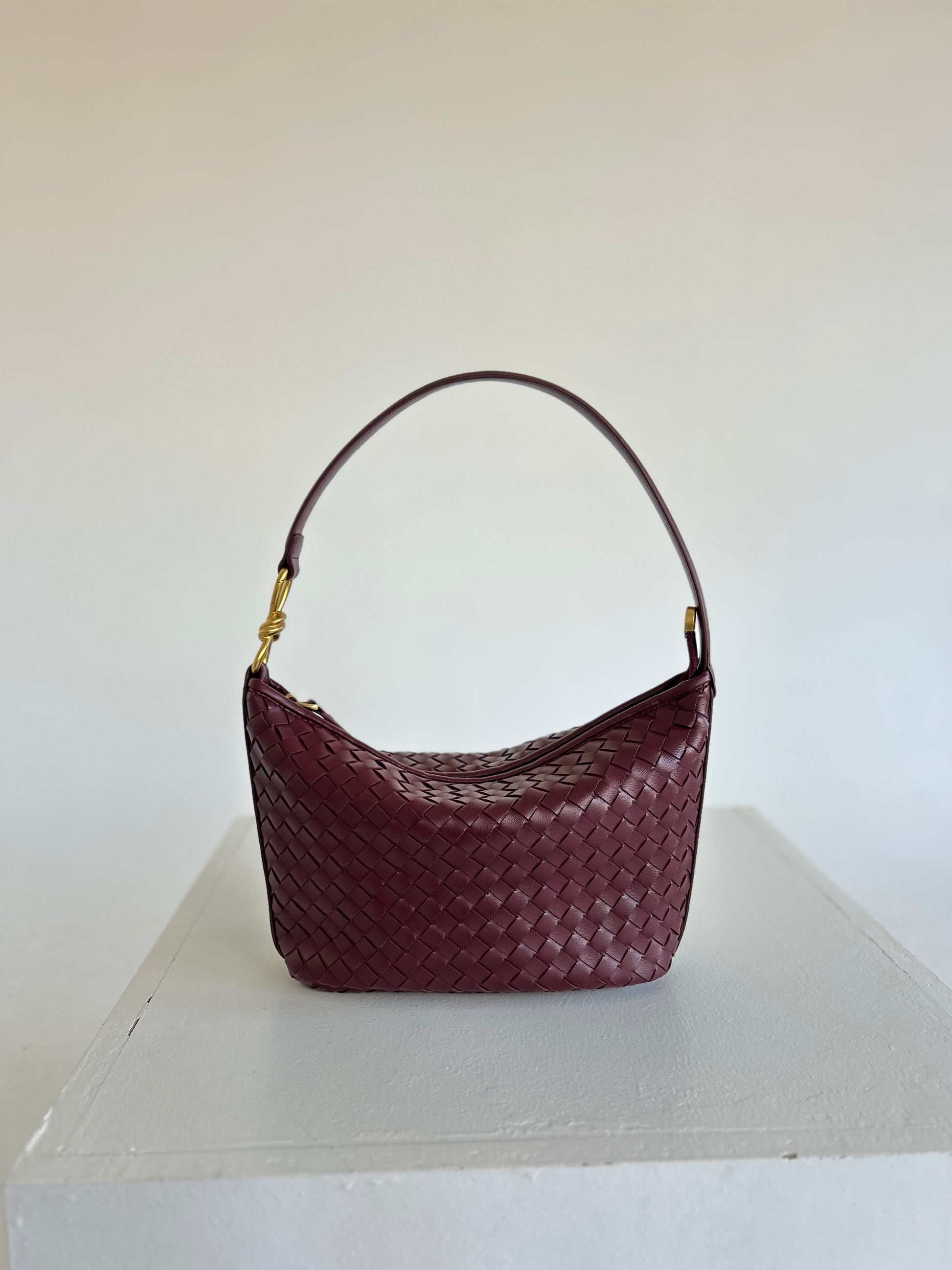 Stylish Woven Shoulder Bag placed casually on a cream sofa with minimalist pillows, Elegant Braided Handbag in burgundy colour is suitable for Everyday Carry, Hobo Woven Bag Practical Bag for Work Braided Handle Handbag, best birthday Gift for Wife