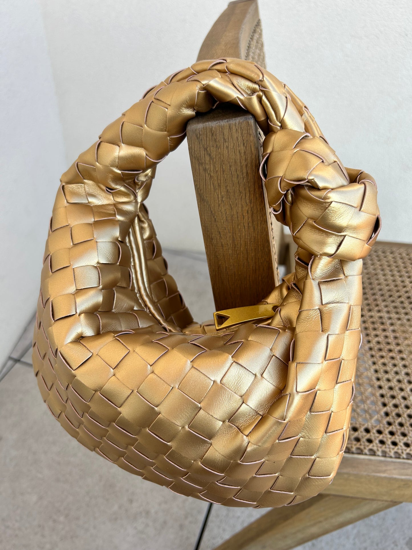 Step into the spotlight with this luxurious gold woven handbag, crafted for women who love bold style with a modern edge. This small but mighty top handle bag is made from high-quality vegan leather, showcasing an intricate woven texture that channels effortless cool-girl energy. The soft, padded finish and sculptural silhouette make it a head-turning accessory whether you’re brunching in the city or dancing the night away.