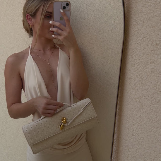 Minimalist cream crossbody bag with woven texture and detachable strap