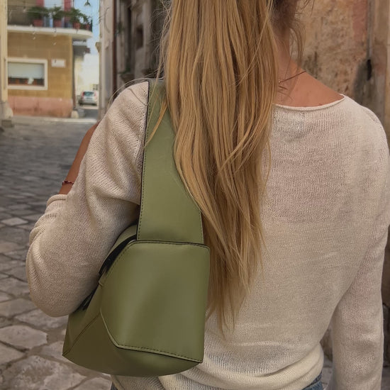 woman wearing a gree puzzle bag made from vegan leather in highest quality