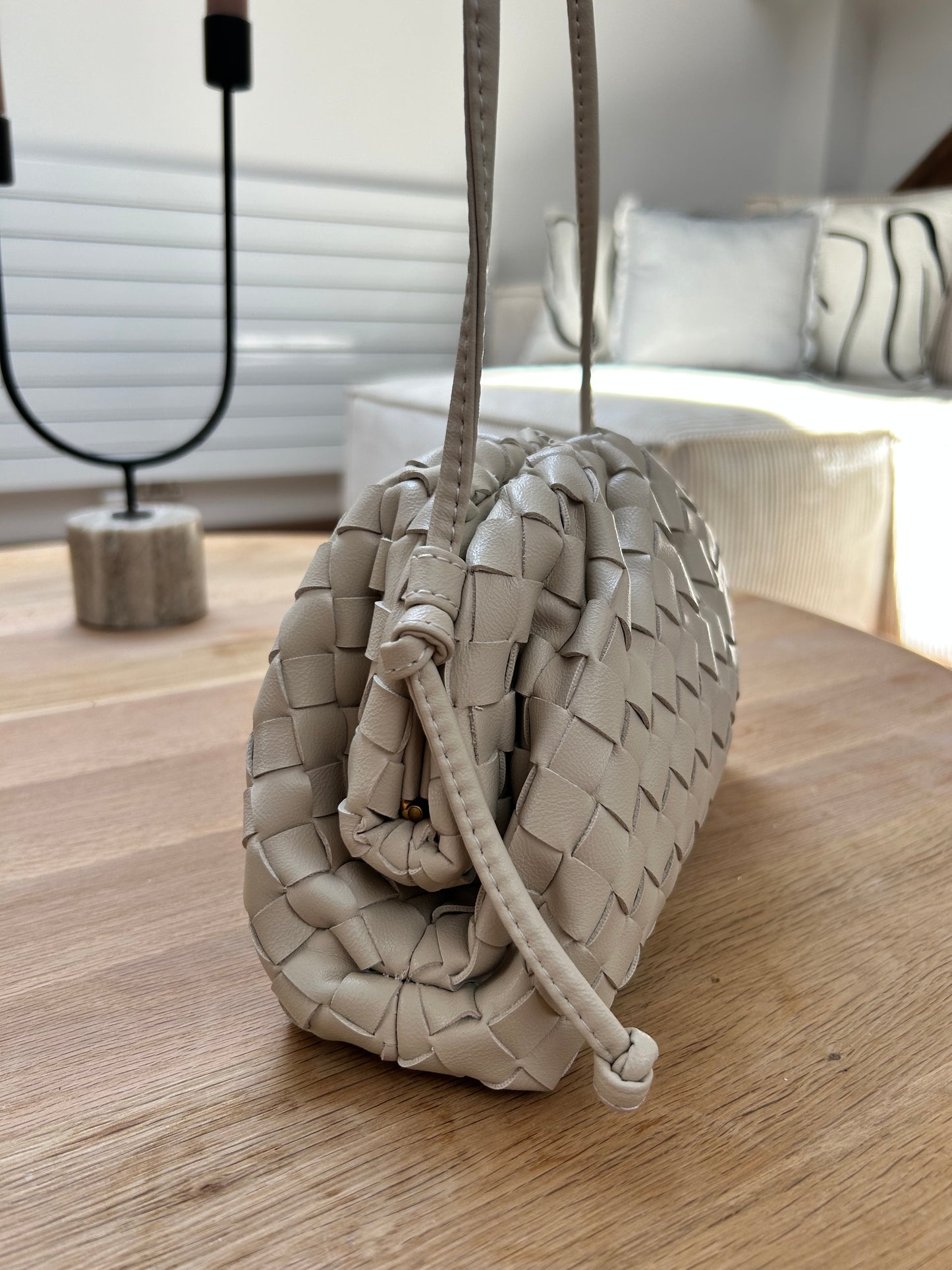 side view of a woven crossbody cloud bag