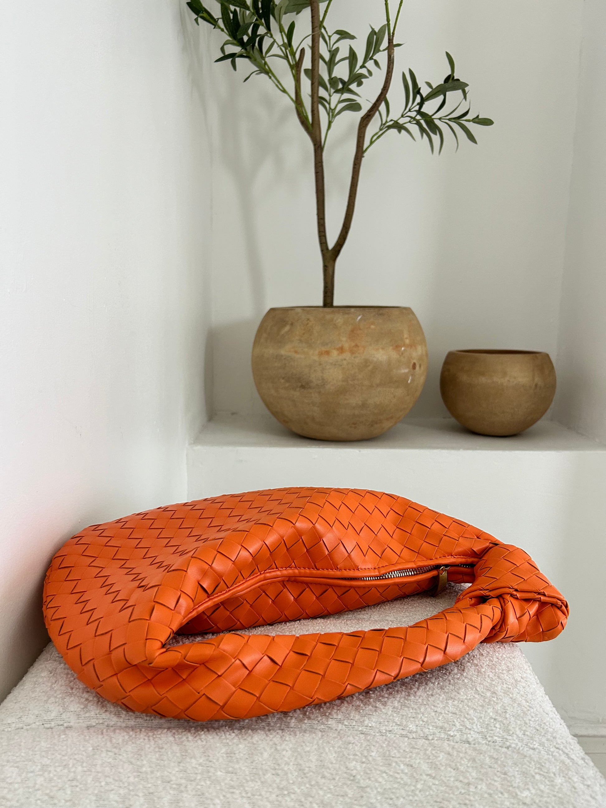 orange woven leather bag, large leather shoulder bag, spring trend handbag, luxury statement bag, bold color leather purse, woven leather tote, triangle zip handbag, artisanal orange handbag, modern designer-inspired bag, spacious woven bag